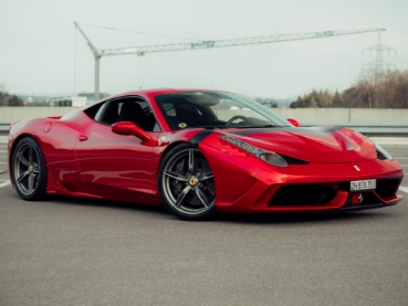 アスファルト上に停まる赤いフェラーリのスポーツカー